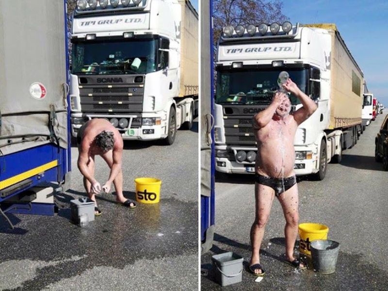 Български шофьор се къпе пред камиона си по време на блокадата СНИМКА