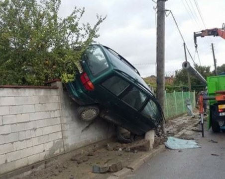 Зрелищна каскада! Кола връхлетя ограда на селска къща и се настани трайно отгоре ѝ СНИМКА