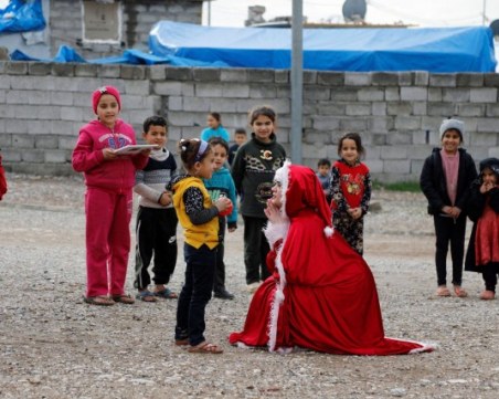 Иракчанка, облечена като Дядо Коледа, зарадва разселени деца