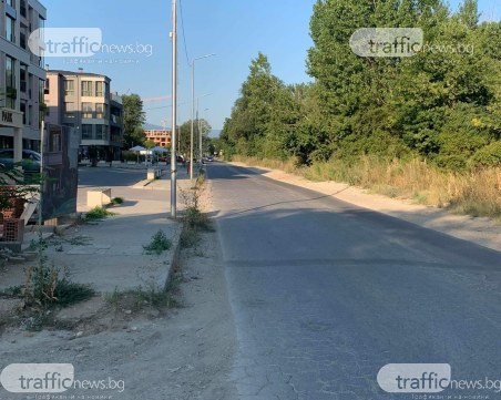 Пешеходци и майки с колички вървят покрай камиони и коли в един от новите пловдивски квартали