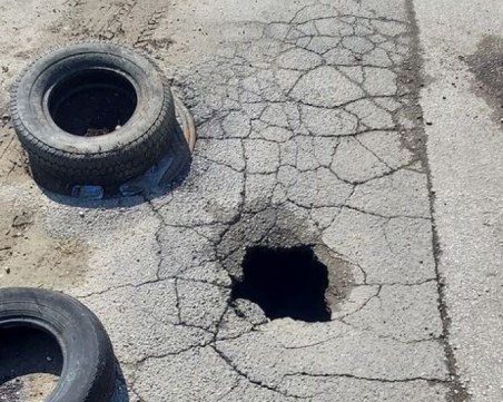 Стари гуми предупреждават за голяма дупка на улица в Пловдив