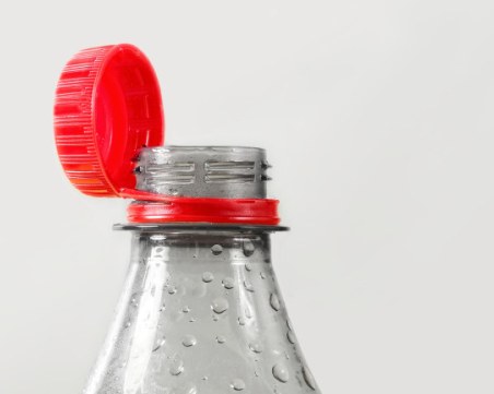 Защо капачките на някои пластмасови бутилки са закрепени към тях